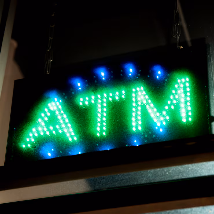 close-up-atm-sign-neon-lights_23-2148283898
